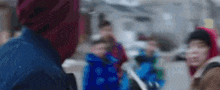 a blurry picture of a group of people walking down a street in the snow .