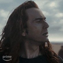 a man with long red hair has a tattoo on his ear that says ' snake ' on it