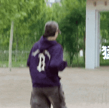 a person wearing a purple hoodie with the number 8 on it