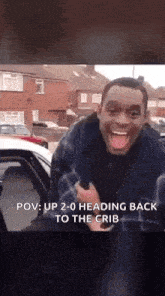 a man is standing in front of a car with his tongue out and says pov : up 2-0 heading back to the crib .