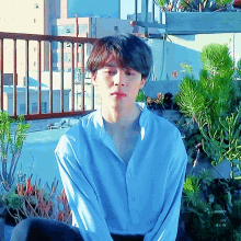 a man in a blue shirt sits on a balcony