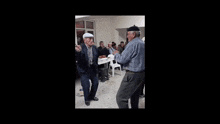 two older men are dancing with a young boy in a room with other people
