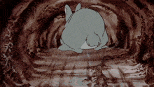 a cartoon rabbit is laying on the ground in a dark cave