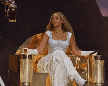 a woman is sitting on a gold throne holding a glass