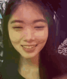 a close up of a woman 's face smiling with her eyes closed .