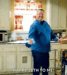 a man in a blue shirt is dancing in a kitchen with the words happy 28th to me .
