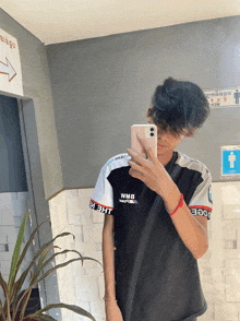 a man taking a picture of himself in a mirror with a shirt that says bmw on it