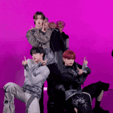 a group of young men are posing for a picture with a purple background