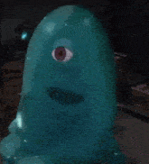 a blue balloon with a red eye on it is sitting on a table .