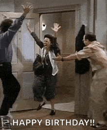 a group of people are jumping in the air in a doorway while a man holds a woman 's hand .