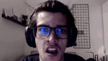 a man wearing glasses and headphones making a face