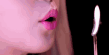 a woman blowing out a birthday candle with pink lips