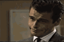 a man in a suit and tie is making a silly face