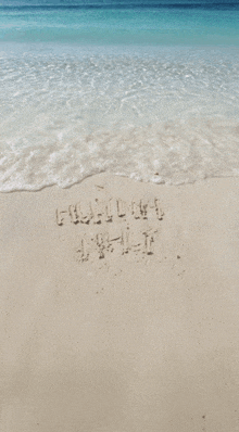 the word hawaii is written in the sand near the ocean