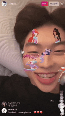 a man is laying on a bed with stickers on his face and a live button