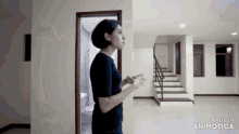 a woman is standing in an empty room with the words made in animatica on the bottom right