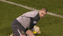 a soccer player with the word barclays on his shorts is kneeling down to catch a ball