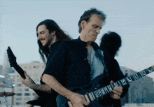 a man playing a guitar with the letters a and b on it