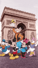 a group of mickey mouse and friends are standing in front of a building