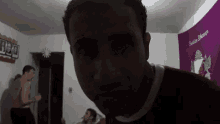a man in a red shirt is making a funny face in a dark room