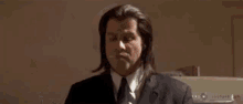a man in a suit and tie is pouring a bottle of wine into a laptop .