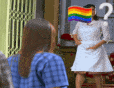 a woman in a white dress with a rainbow flag on her face