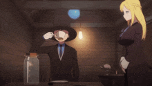 a man and a woman are standing in a room with a light hanging from the ceiling