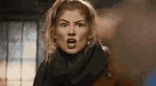 a woman is making a surprised face while standing in a room .