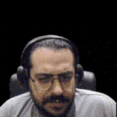 a man with a beard wearing headphones and glasses