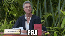 a woman in a judge 's robe is sitting at a table in front of a sign that says pfui .