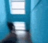 a blurry picture of a person in a blue room