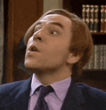 a man in a suit and tie is looking up at something