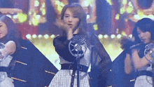 a woman is standing in front of a microphone on a stage in front of a crowd .