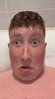 a man with red hair and freckles is making a funny face