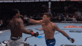 a man in a venum shorts is fighting another man
