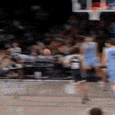 a blurry picture of a basketball game with a crowd in the stands