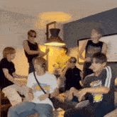a group of young men are sitting on a couch and dancing in a living room .