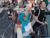 a woman with blue hair and a skull on her head is standing on an escalator