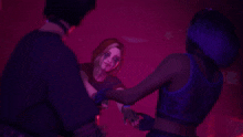 a group of people are dancing in a dark room with red lights