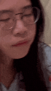 a close up of a woman wearing glasses making a face .