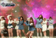 a group of girls are dancing on a stage in front of a sign that says ' hot debut '