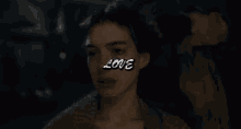 a close up of a woman 's face with the word love on it