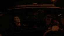 a group of people are sitting in a car at night and one of them is smiling