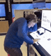 a man wearing headphones is looking at a display for beats studio pro