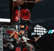 a person riding a dirt bike in front of a banner that says last lap