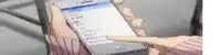 a person in a pink sweater is holding a cell phone with a foreign language on the screen