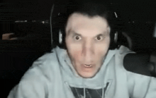 a man wearing headphones is making a funny face while looking at the camera .