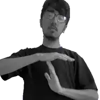 a man wearing glasses and a black shirt is making a stop sign with his hands
