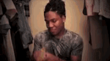 a man is sitting in a closet holding a bottle of water .