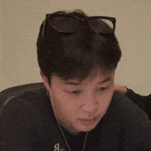 a close up of a person wearing sunglasses and a black shirt with the letter a on it